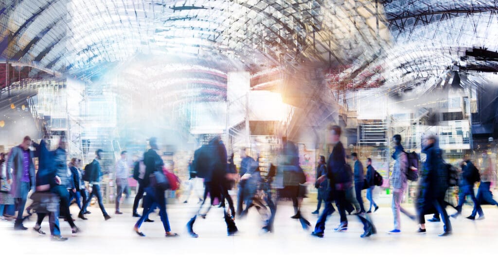 Beautiful motion blur of walking people in train station. Early morning rush hours, busy modern life concept. Ideal for websites and magazines layouts