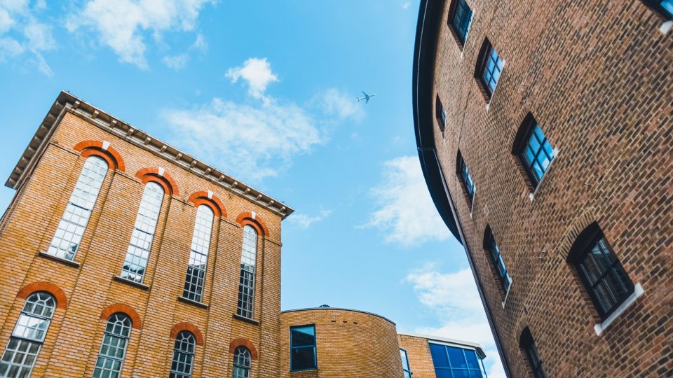 The plane flies over the ancient streets of London