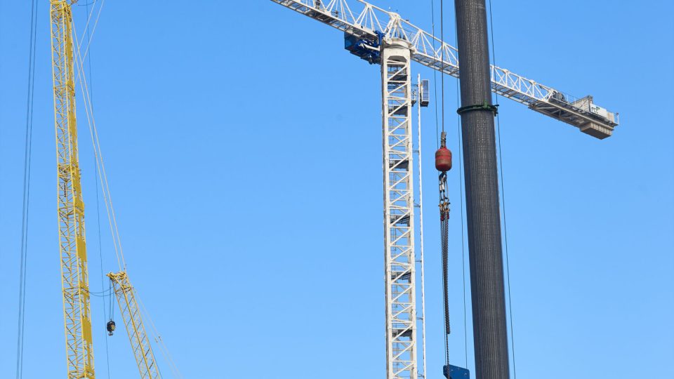 Telescopic cranes under a blue sky. Construction engineering industry